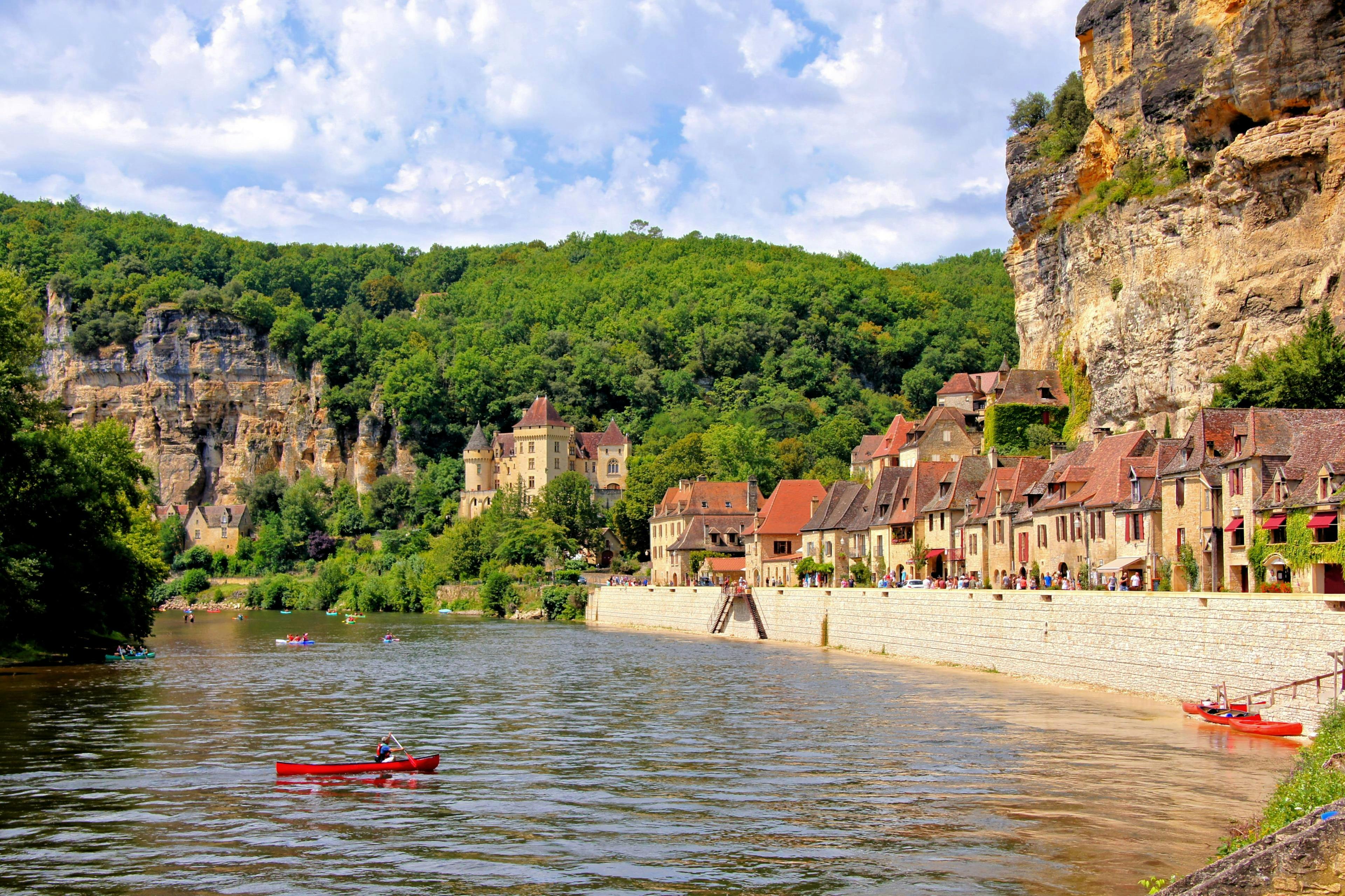 Belle vue du village de La Roque-Gageac sur la rivière Dordogne sur laquelle les touristes font du canoë pendant l'été.
