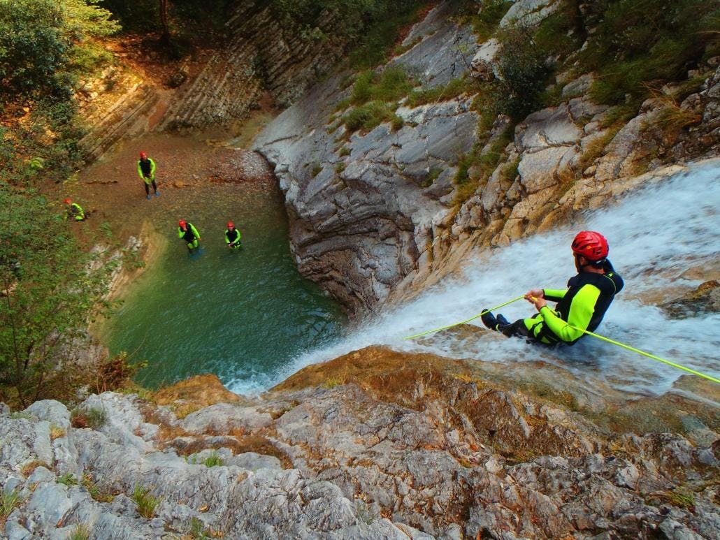 Un partecipante sta scivolando nel canyon durante uno dei Canyoning nel Torrente Vione al Lago di Garda.