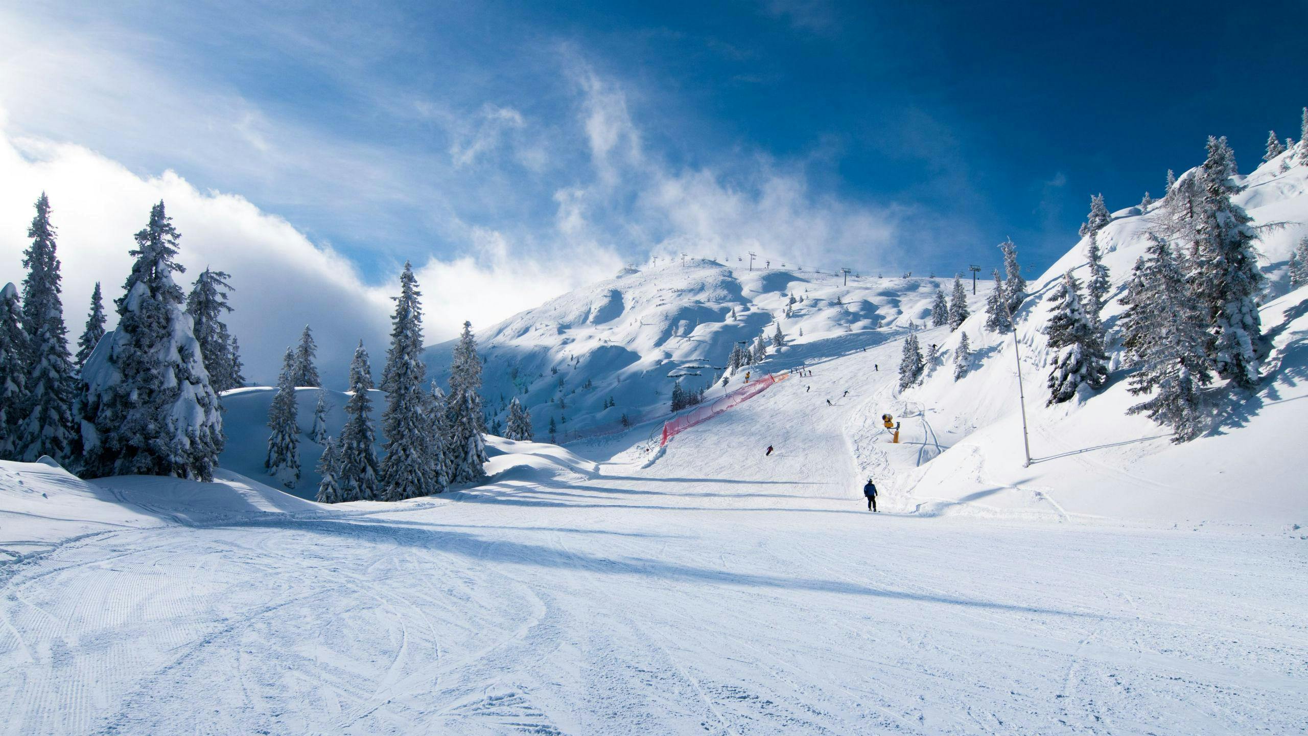 ski-school-andalo_SEM-Resort-Hero Una coppia di sciatori scia lungo una pista da sci appena battuta nella stazione sciistica italiana di Andalo, dove le scuole di sci locali offrono numerose lezioni di sci.
