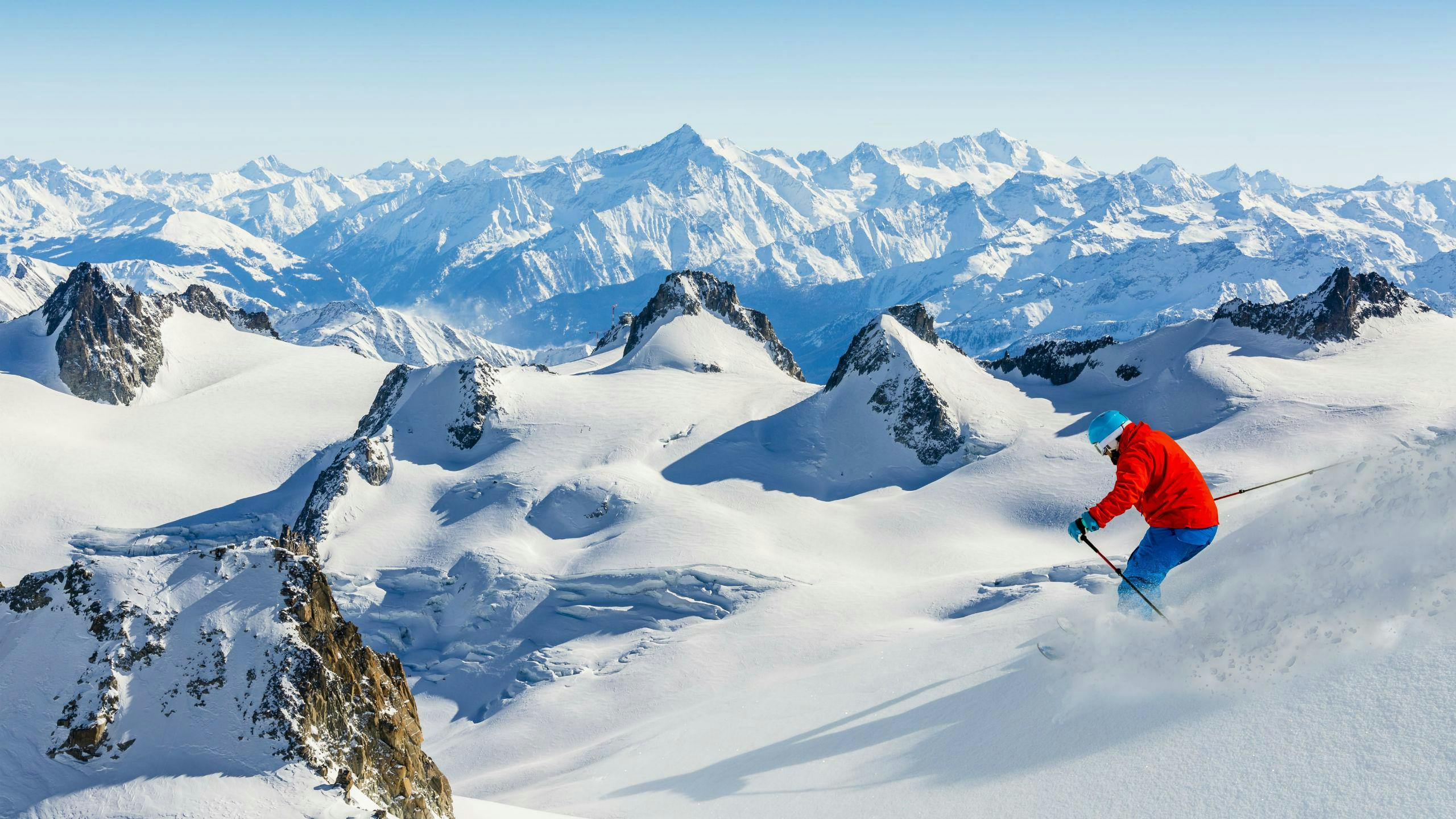 A skier is skiing through fresh powder snow on one of the slopes in Chamonix Village, where local ski schools offer a variety of ski lessons.