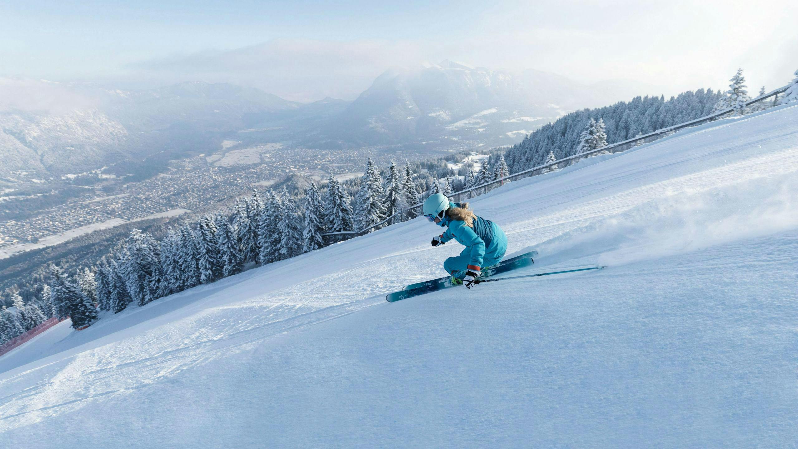ski-school-garmisch_SEM-Resort-Hero_(c)Bayerische Zugspitzbahn Bergbahn AGfendstudios.com Eine Skifahrerin zieht eine perfekt präparierte Piste mit Blick auf das Skigebiet Garmisch-Classic hinunter, wo auch die örtlichen Skischulen eine Bandbreite an Skikursen anbieten. (c)Bayerische Zugspitzbahn Bergbahn AGfendstudios.com