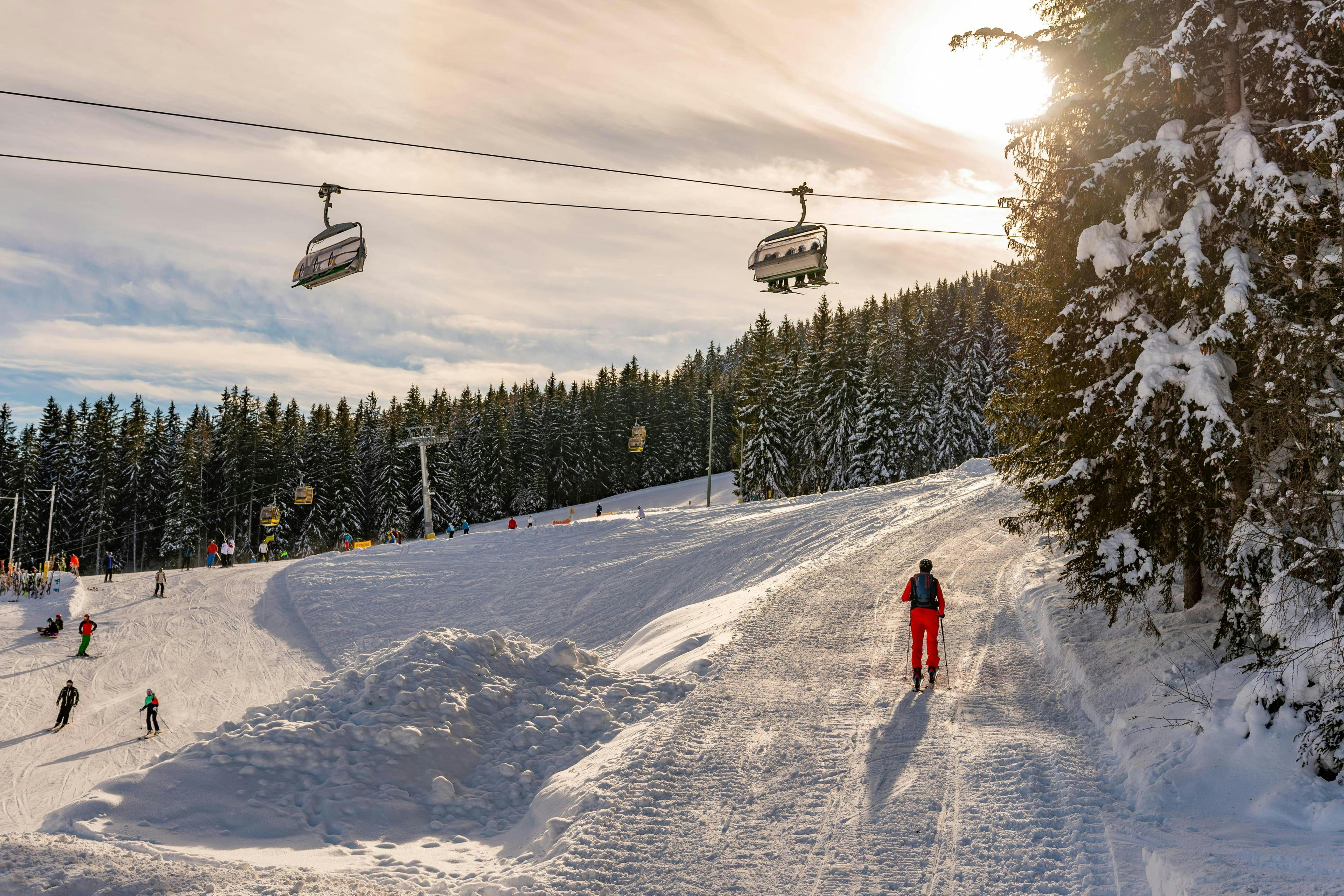 Blick auf die Pisten und einen Sessellift im Skigebiet Schladming - Planai, wo die örtlichen Skischulen ihre Skikurse anbieten.