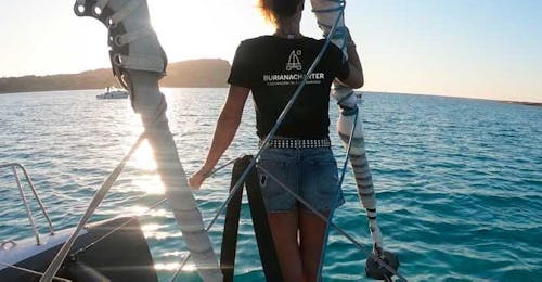 Giro in catamarano al tramonto nel Parco Nazionale dell'Asinara con Buriana Charter Stintino Una ragazza mentre si gode il tramonto durante il giro in catamarano al Parco Nazionale dell'Asinara con Buriana Charter Stintino.